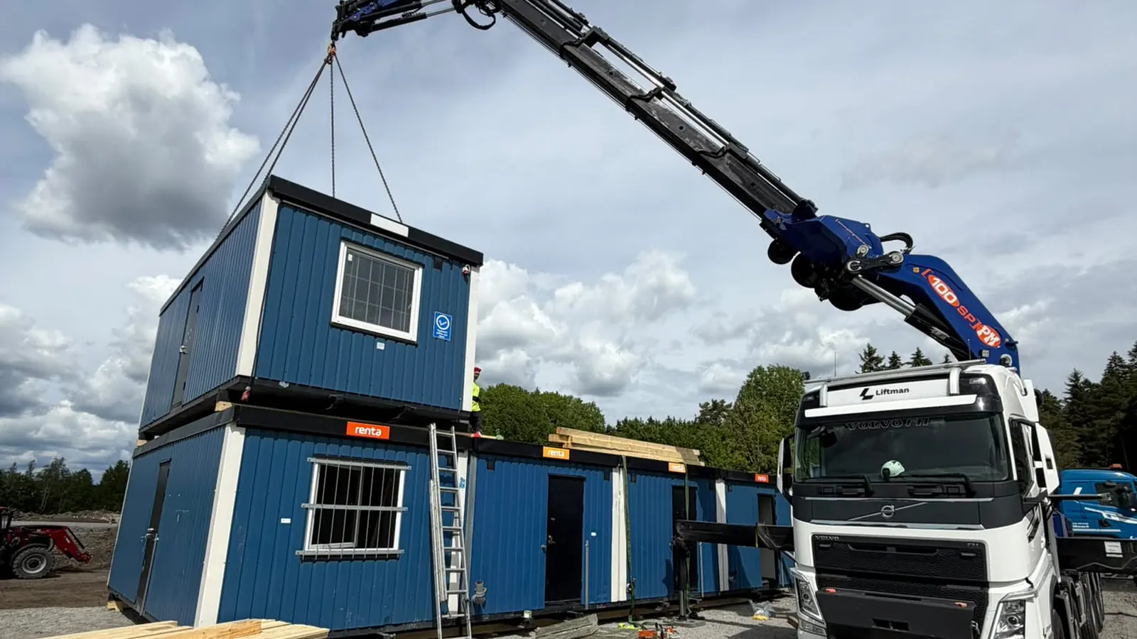 Liftmanin nosturiauto nostaa työmaaparakkia paikoilleen työmaalla